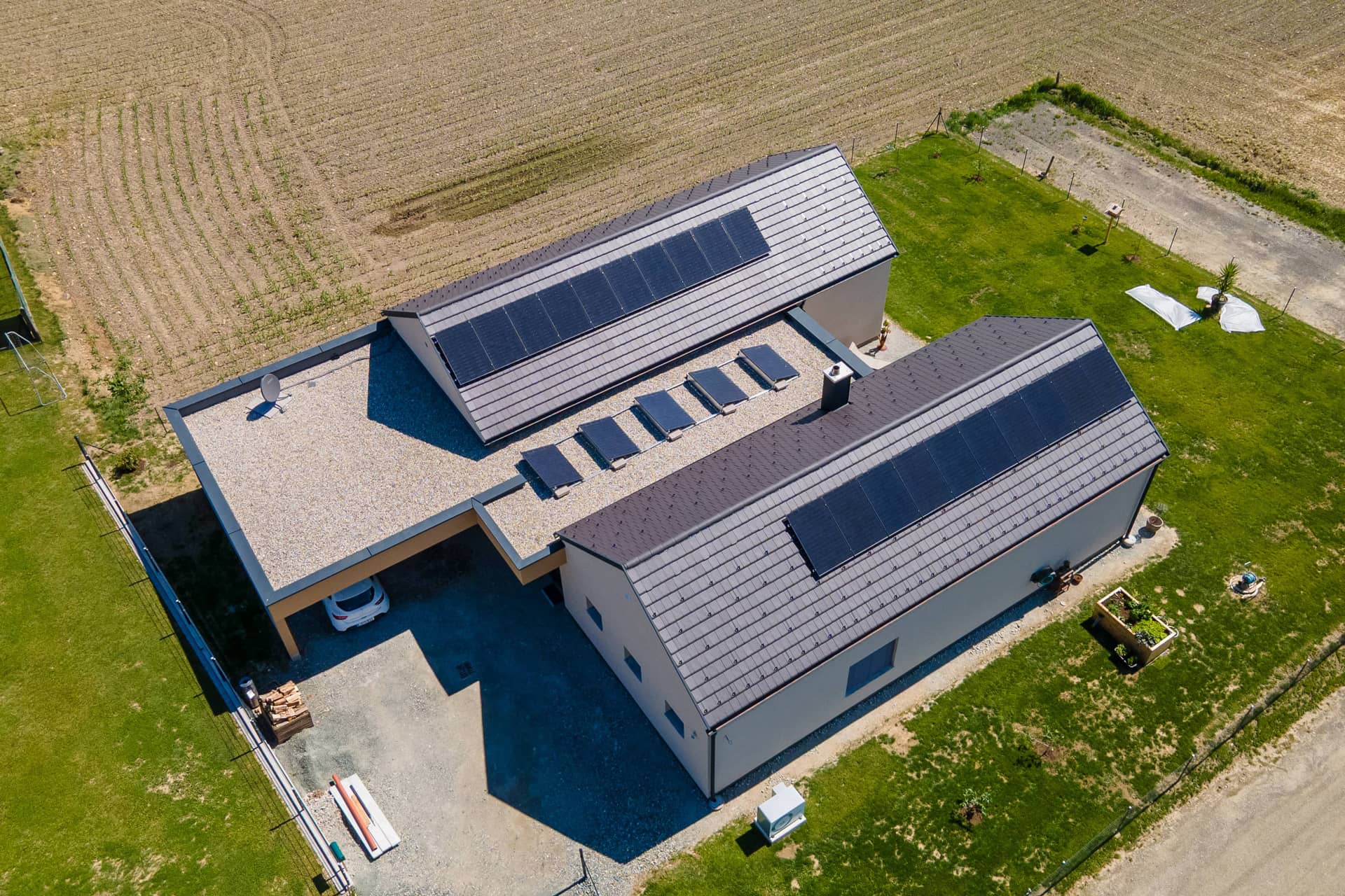 Mordernes Haus mit zwei parallel gebauten Gebäudeteilen mit anthrazitfarbigen Satteldächern.