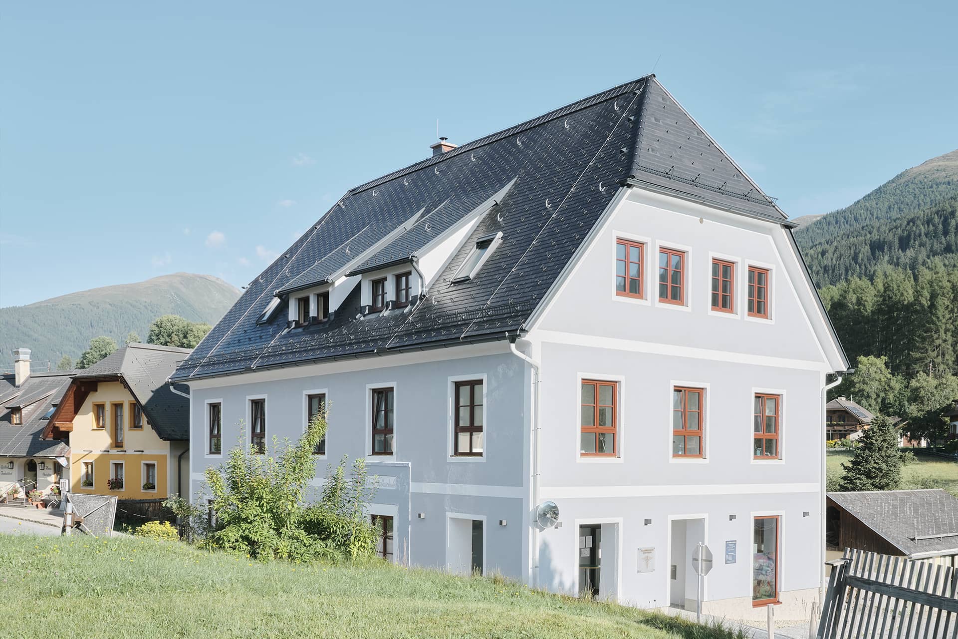 Das Bild zeigt ein modernes Haus mit grauem Satteldach der Marke Swisspearl.