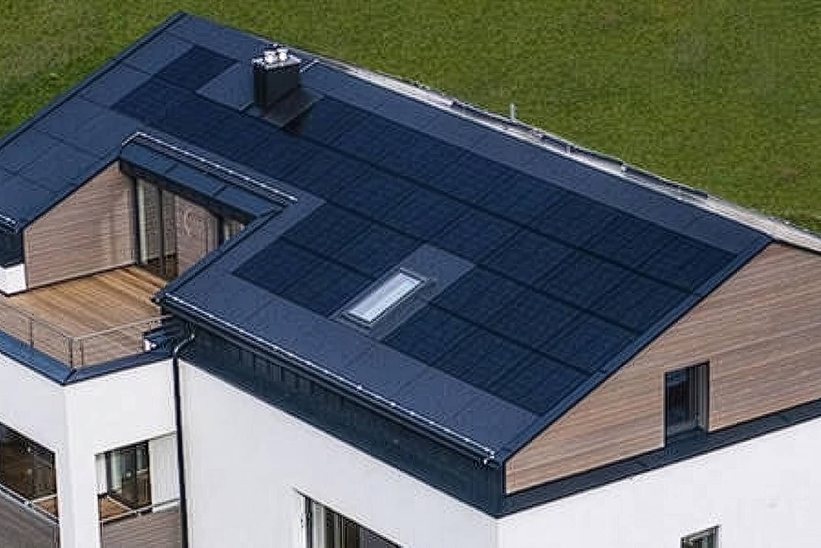 Das Bild zeigt ein modernes Haus mit Satteldach und integrierten PV-Modulen.