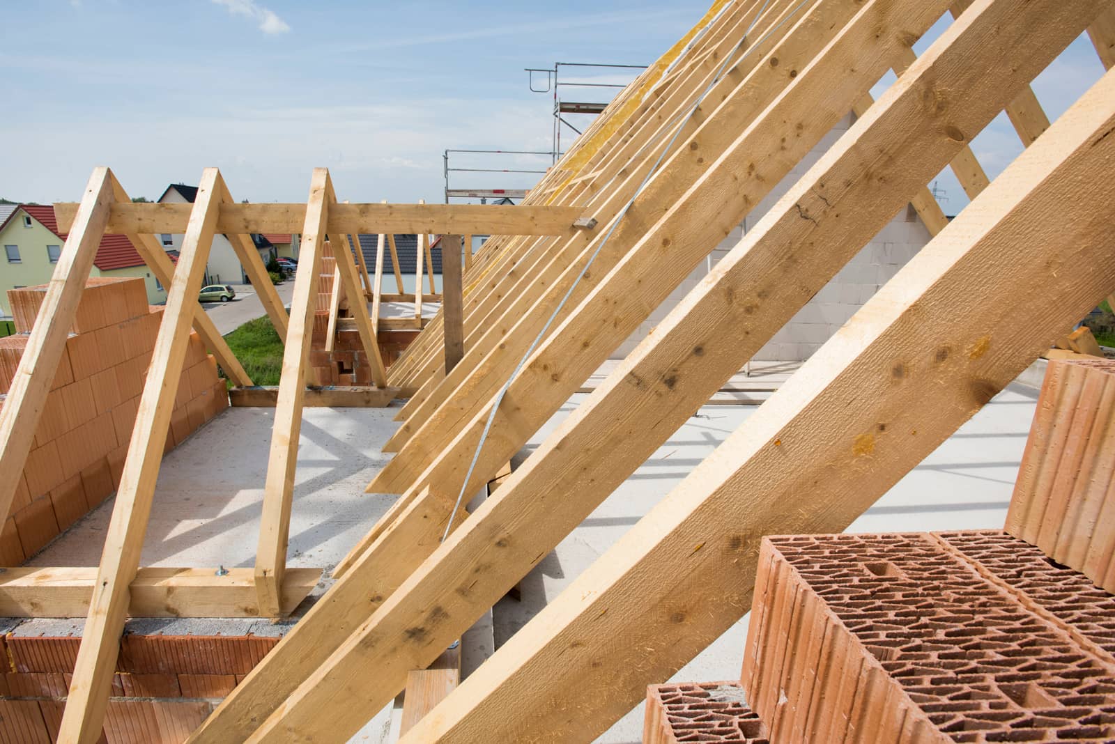 Das Bild zeigt einen Dachstuhl im Rohbau mit Holzbalken.